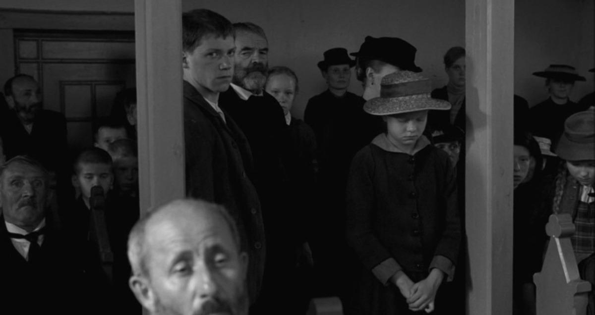 Кадр из фильма: жители деревни в церкви слушают барона