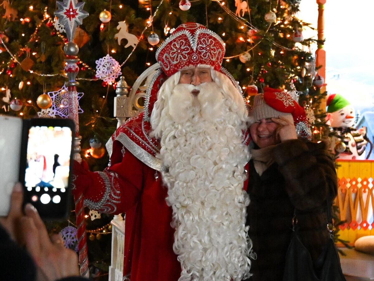    Посетительница делает совместное фото с Дедом Морозом в его Вотчине в Великом Устюге© РИА Новости / Алексей Филиппов