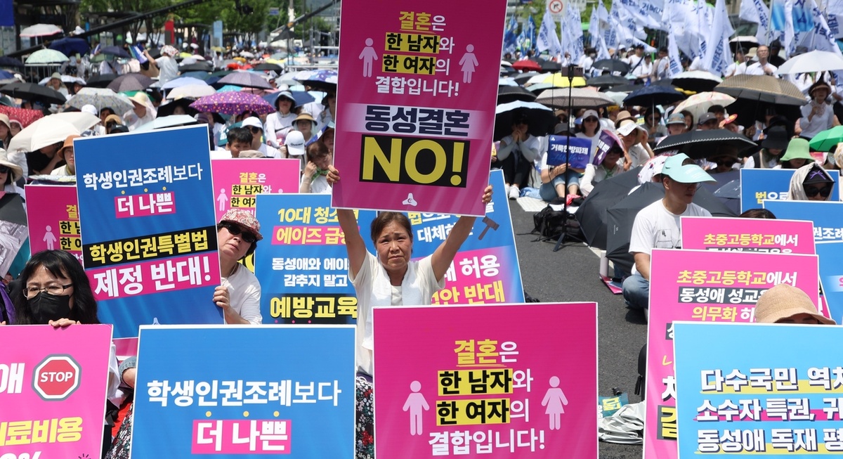 В июне консервативные организации провели масштабный митинг против Сеульского фестиваля квир-культуры и законодательных инициатив по защите прав представителей половых меньшинств в центре Сеула. Женщина в первых рядах держит ярко-розовый плакат с надписью «Брак заключается между одним мужчиной и одной женщиной. Нет однополым бракам» (Newsis)