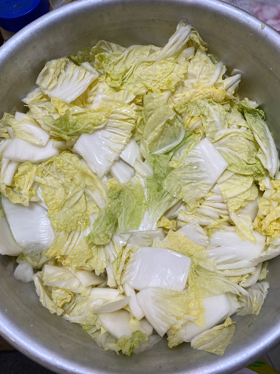 Пекинская капуста набирает вкус, перемешанная с солью и сахаром.