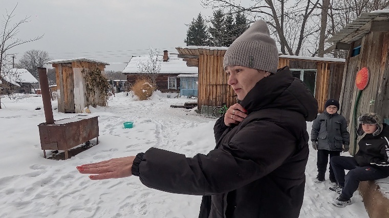 Хозяйка подворья показывает на следы. 