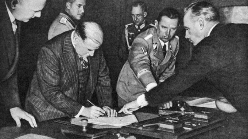 Подписание Мюнхенского соглашения 30 сентября 1938 года. Министр иностранных дел Германии Иоахим фон Риббентроп указывает премьер-министру Франции Эдуару Даладье место для подписи.

