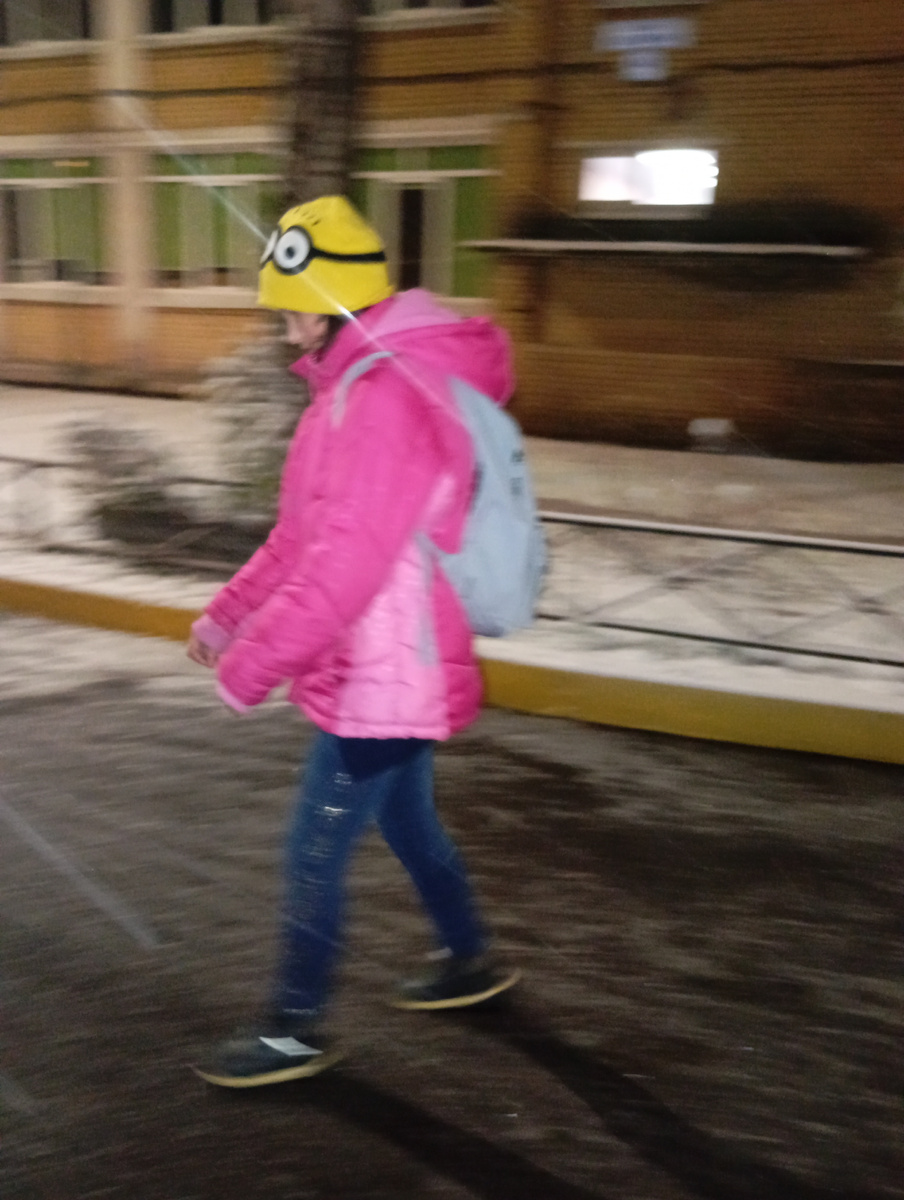 Незрячий ребенок идёт к школьным воротам самостоятельно.