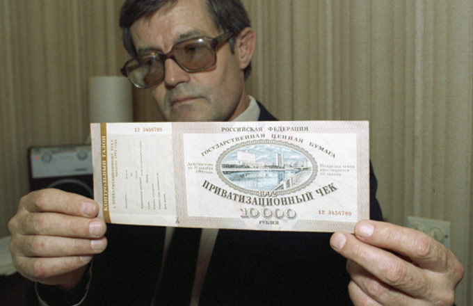 Это ваучер. Помните такой? Тоже был символом приватизации 90-х, как и залоговые аукционы.