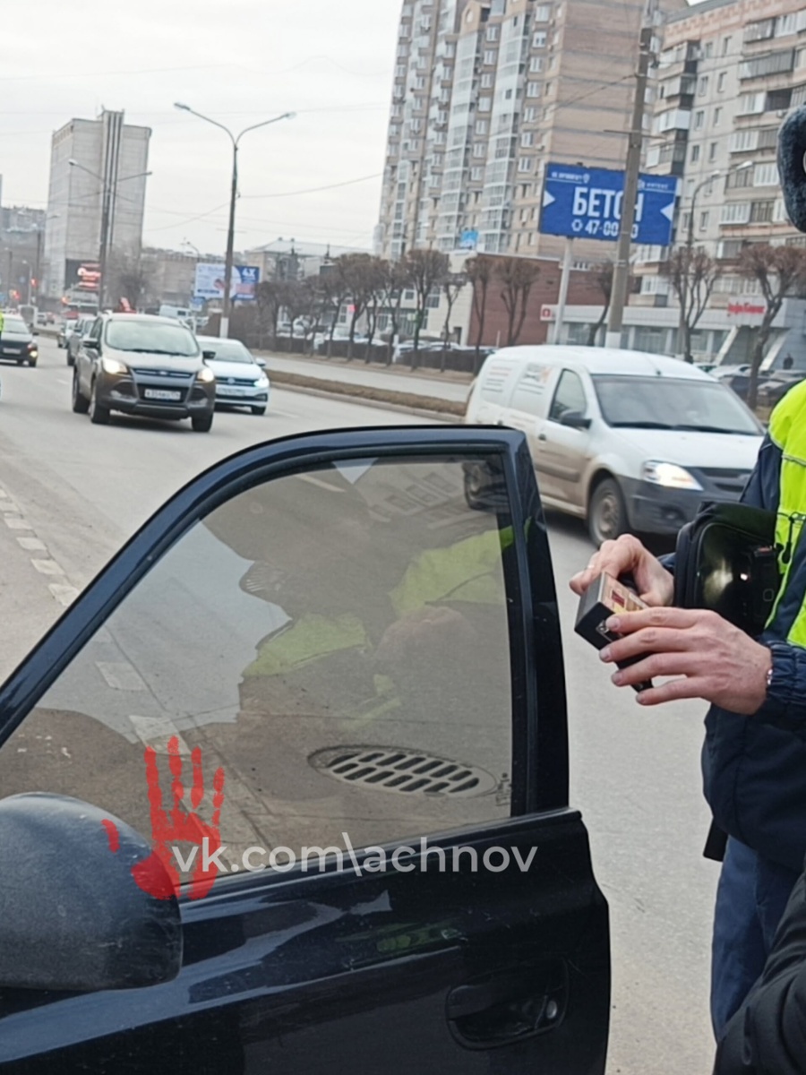 Инспектор ГАИ проверяет светопропускаемость стекл авто