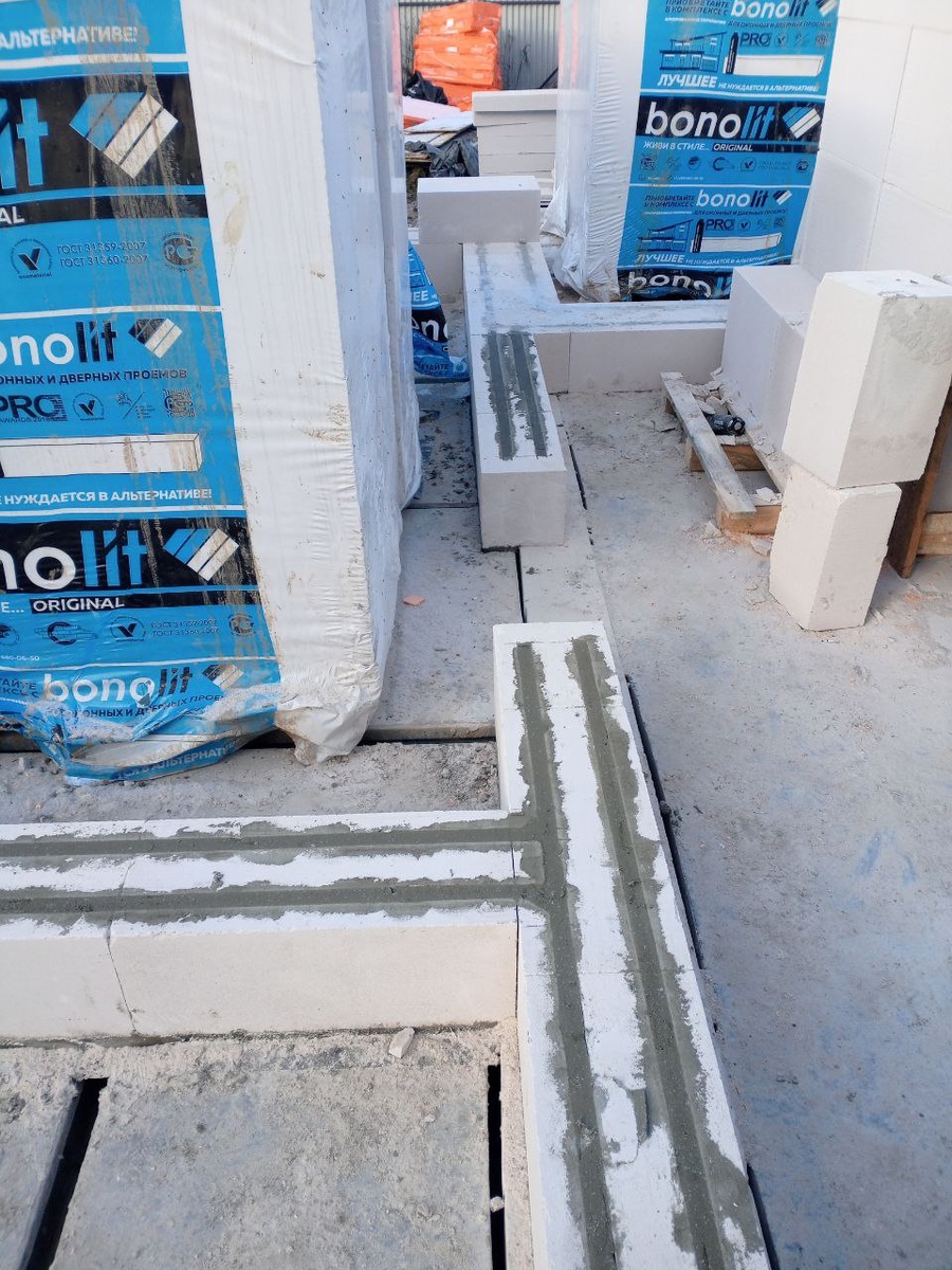  Фото с объекта Интел. Фрагмент работ после укладки первого ряда на цементном растворе: подготовка и армирование перед продолжением кладки. Армирование — обязательный этап, который усиливает кладку и стабилизирует стену.