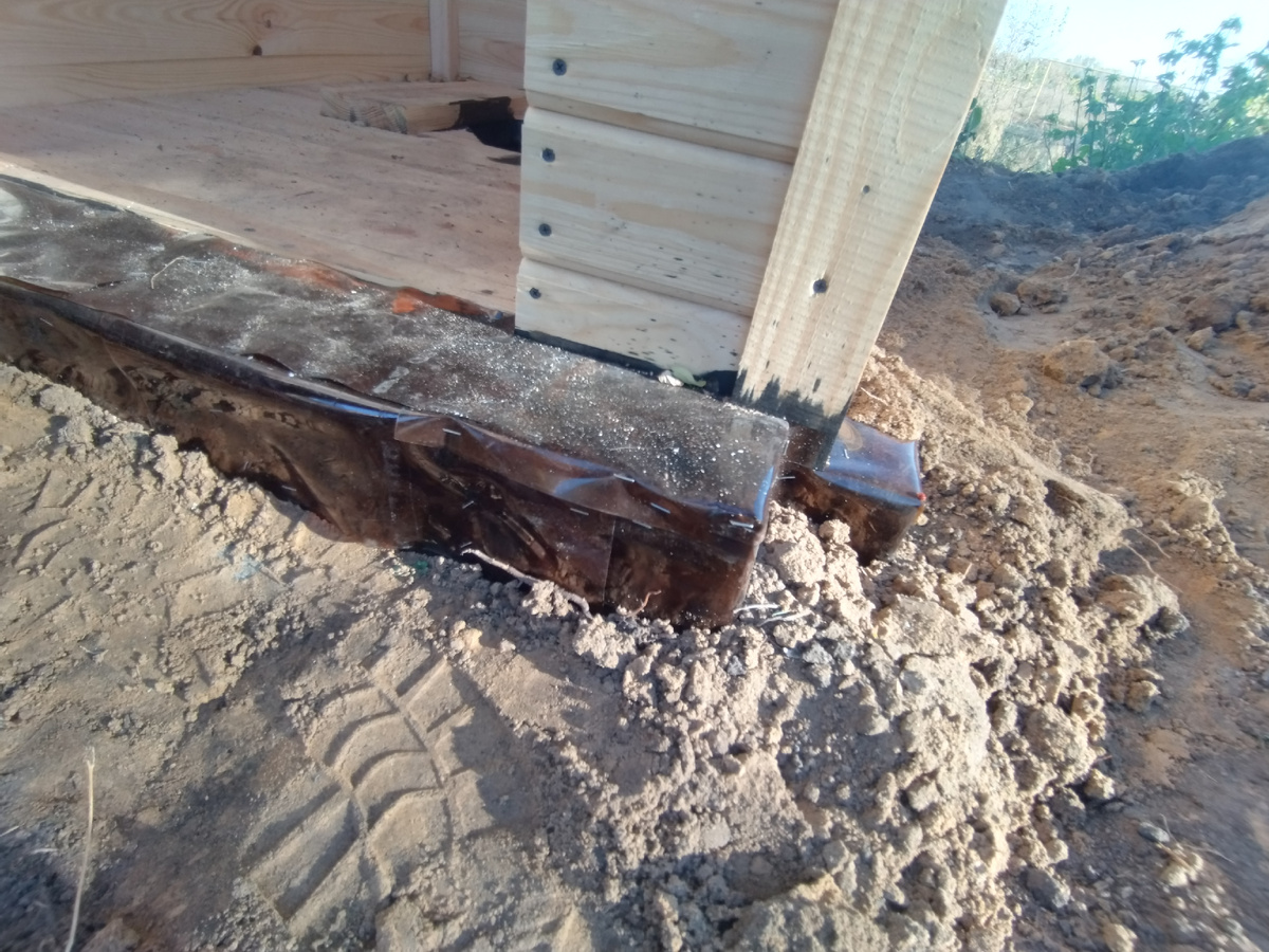 Балки, на которых стоит "домик", пропитали маслом и оббили разрезанными пластиковыми бутылками.