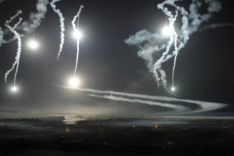 Светящиеся авиабомбы с парашютиками освещают ночные военные учения. Фото из Яндекса.