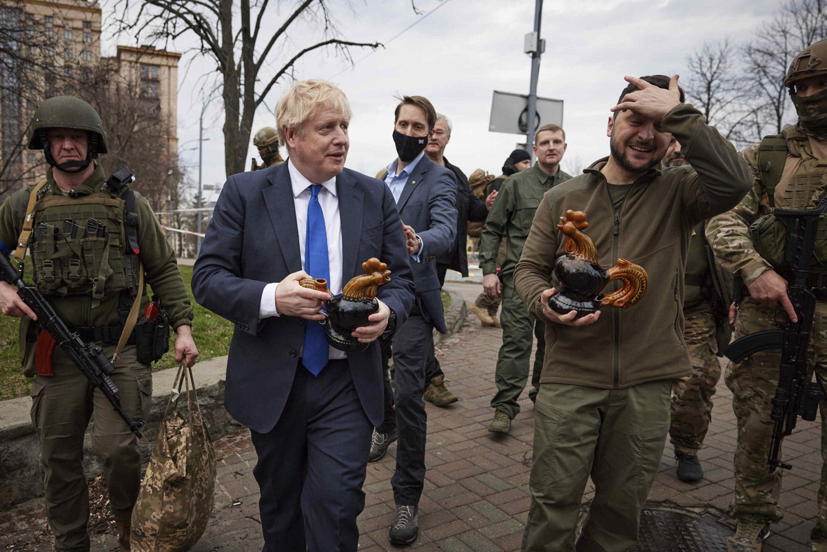    In this image provided by the Ukrainian Presidential Press Office, Ukrainian President Volodymyr Zelenskyy, right, and Britain's Prime Minister Boris Johnson, center left, hold souvenirs presented by a civilian woman in Kyiv, Ukraine, Saturday, April 9, 2022. (Ukrainian Presidential Press Office via AP) Администратор