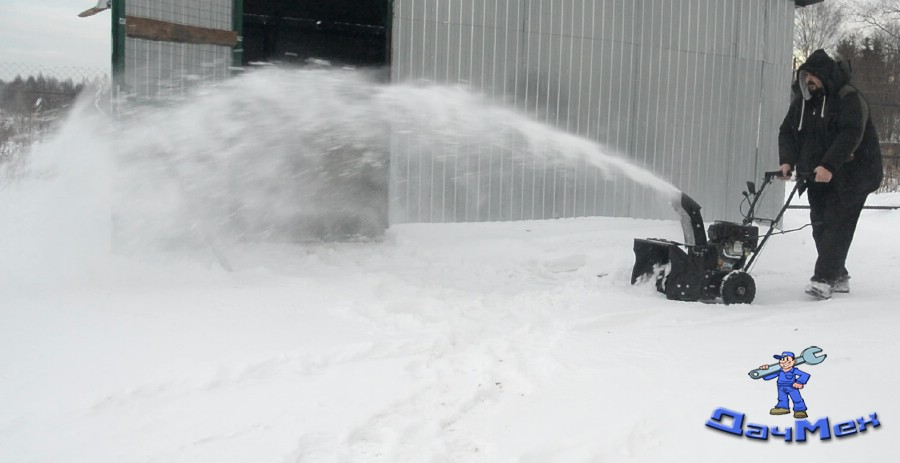 Чищу снег у гаража мелким снегоуборщиком