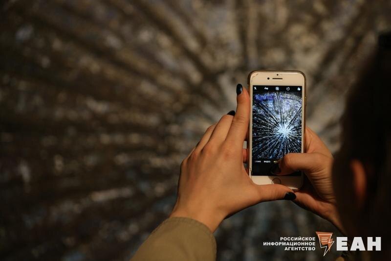    ЕАН. Девушка фотографирует на смартфон