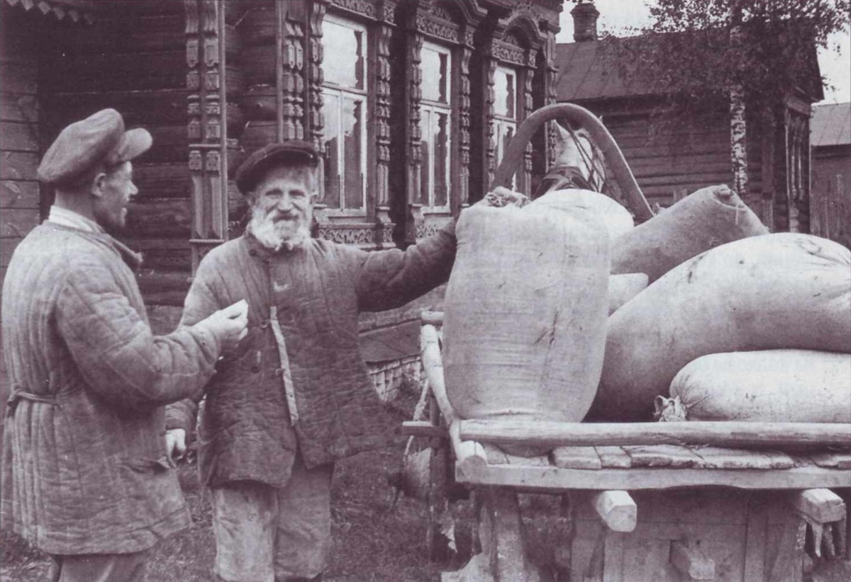    73-летний колхозник колхоза им. 8 Марта Кохомского района Ивановской области В. Д. Семёнов получает аванс на трудодни. Слева - председатель колхоза И. А. Игнатьичев. 1946 г. / РГАКФД / из архива журнала "Родина"