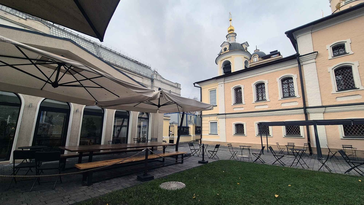 Кофейня-трапезная работает в бывшей хозяйственной постройке. Здание отремонтировали, сделали в нем панорамные окна. В церковном дворе организовали летнюю веранду. Здесь можно выпить кофе с видом на древний храм. Листайте галерею, чтобы увидеть ещё фото