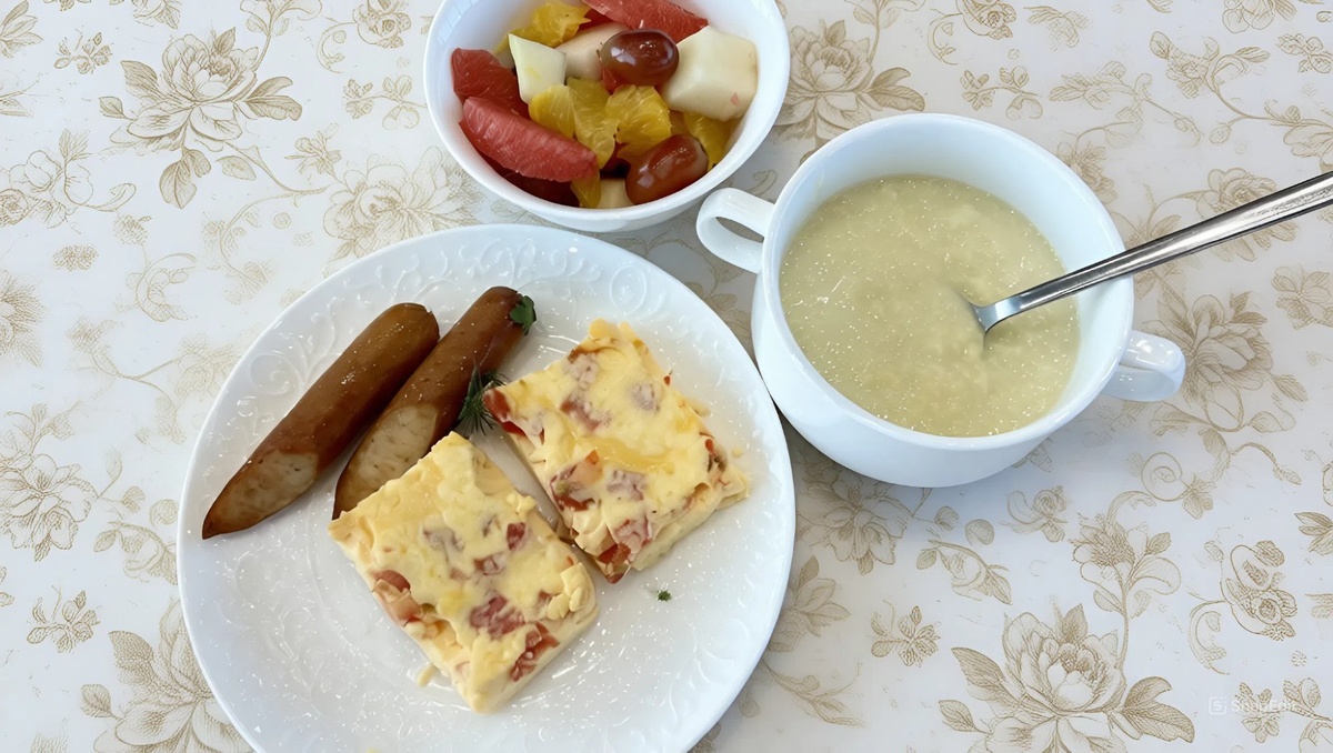 Фрукты, каша и омлет с помидорами — удачная основа для завтрака. Сосиски лучше оставить для редких случаев, так что в целом это скорее компромиссный, а не образцово здоровый вариант.