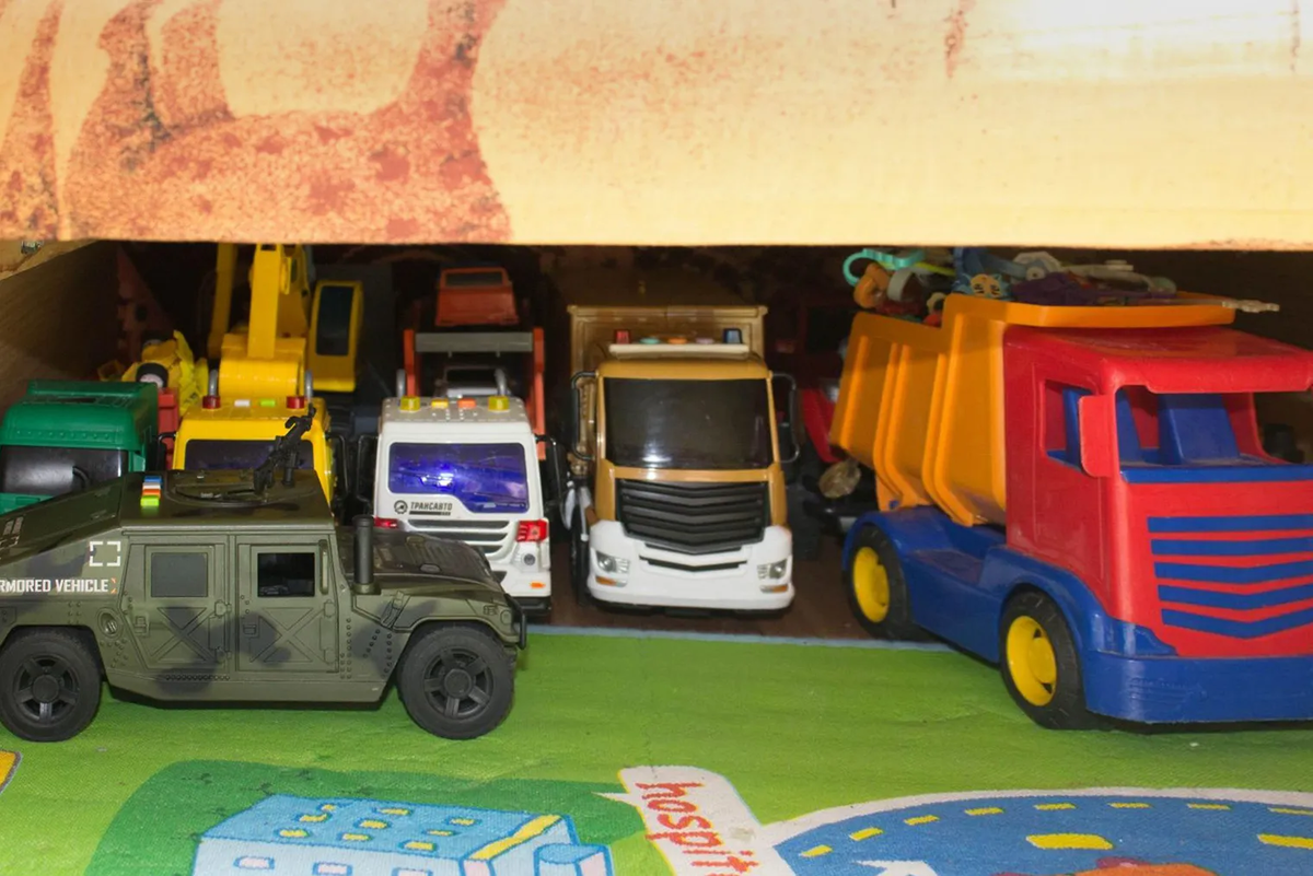 Парковку с машинками можно организовать под кроватью. Но более мелкие игрушки доставать оттуда будет сложно: они могут закатиться слишком далеко