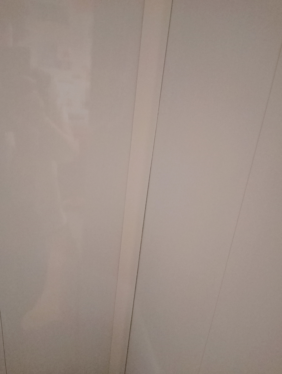 Неудачно поклеенный ощеряющийся уголок. Панели в кухонной зоне сделала белые. Потому что дёшево и мыть можно. Всё по-простому, по-бедному. 