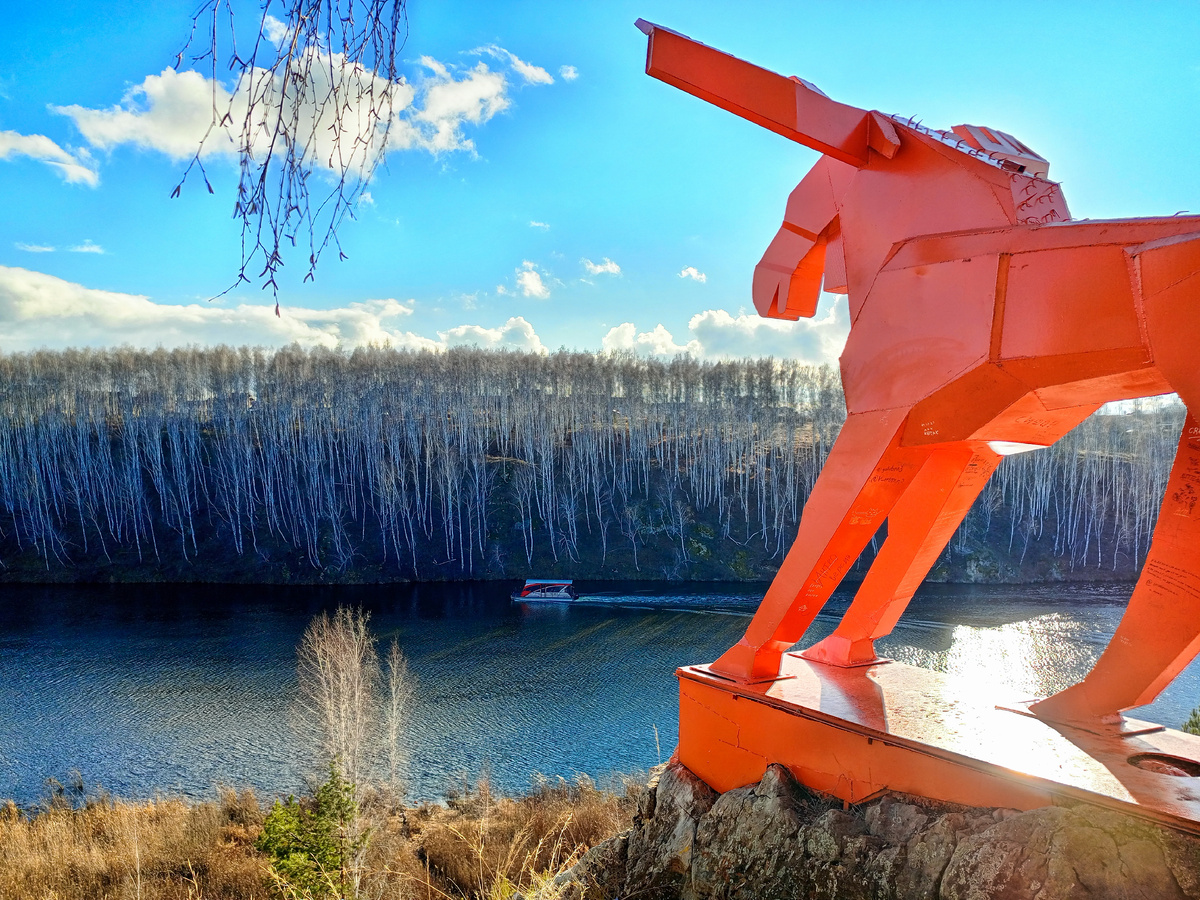 Фигура ярко-оранжевого лося установлена на скале в месте впадения реки Каменки в Исеть в Каменске-Уральском. Фото автора.