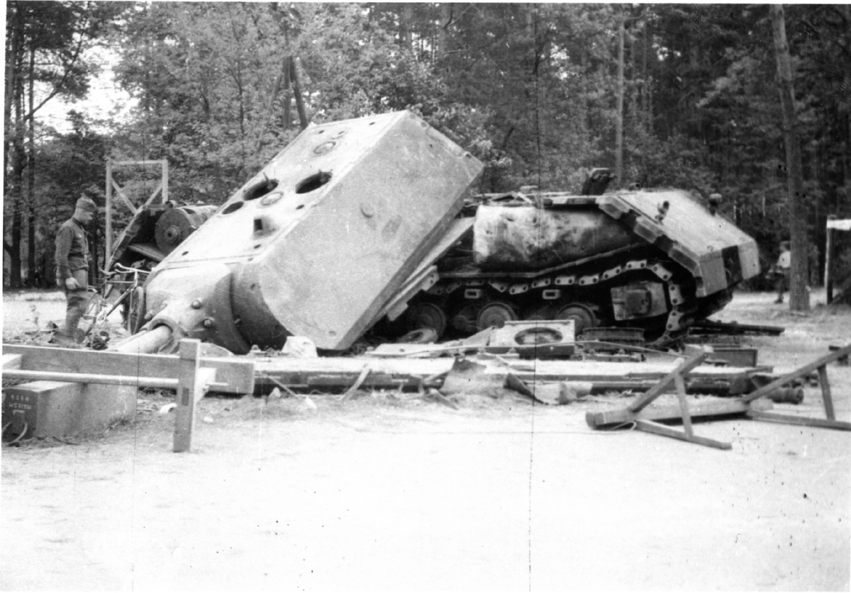Советский солдат осматривает подорванный немецкий сверхтяжёлый танк «Маус» на полигоне в Куммерсдорфе. 1945 год.