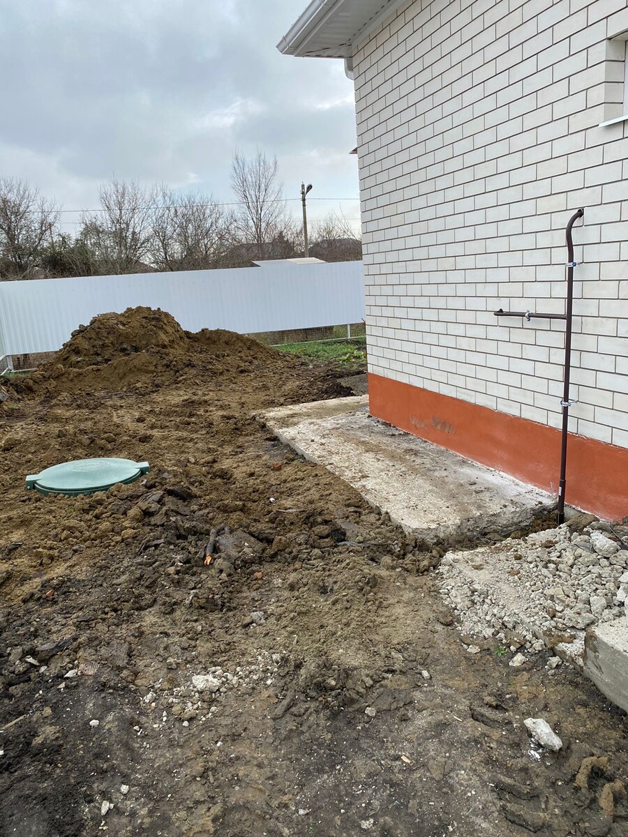 Подземный газгольдер вблизи дома с металлической магистралью 