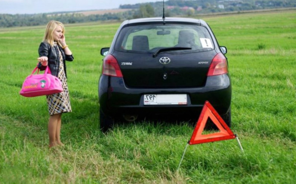 женщина с сумкой едет на машине по плохой дороге