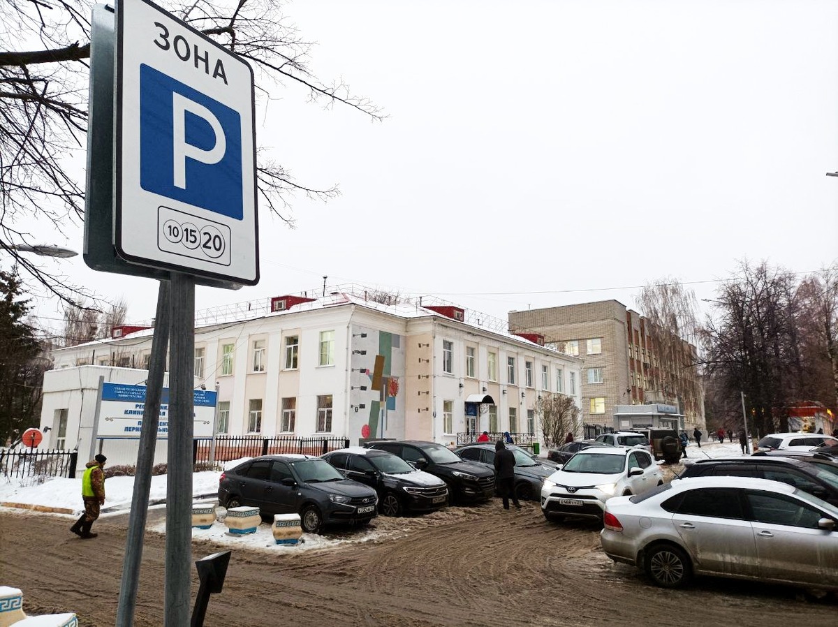 Улица с упорядоченной парковкой и разметкой для платных парковок.