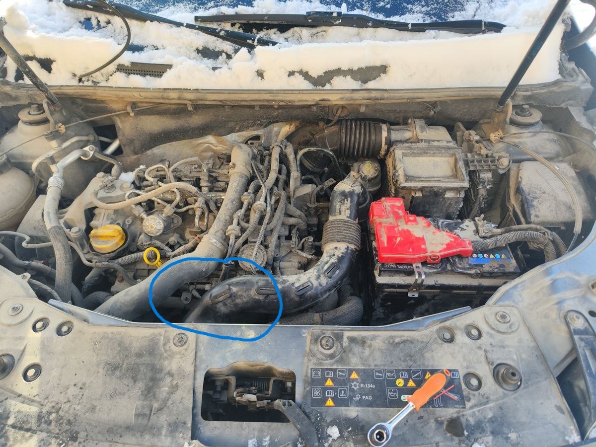 Находится он в передней части двигателя, посередине вот в этой области