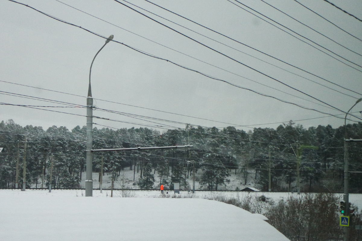 фигурка в оранжевой куртке выделяется среди зимнего однообразия