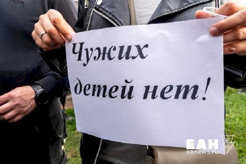    ЕАН. Табличка «Чужих детей нет» в руках волонтера