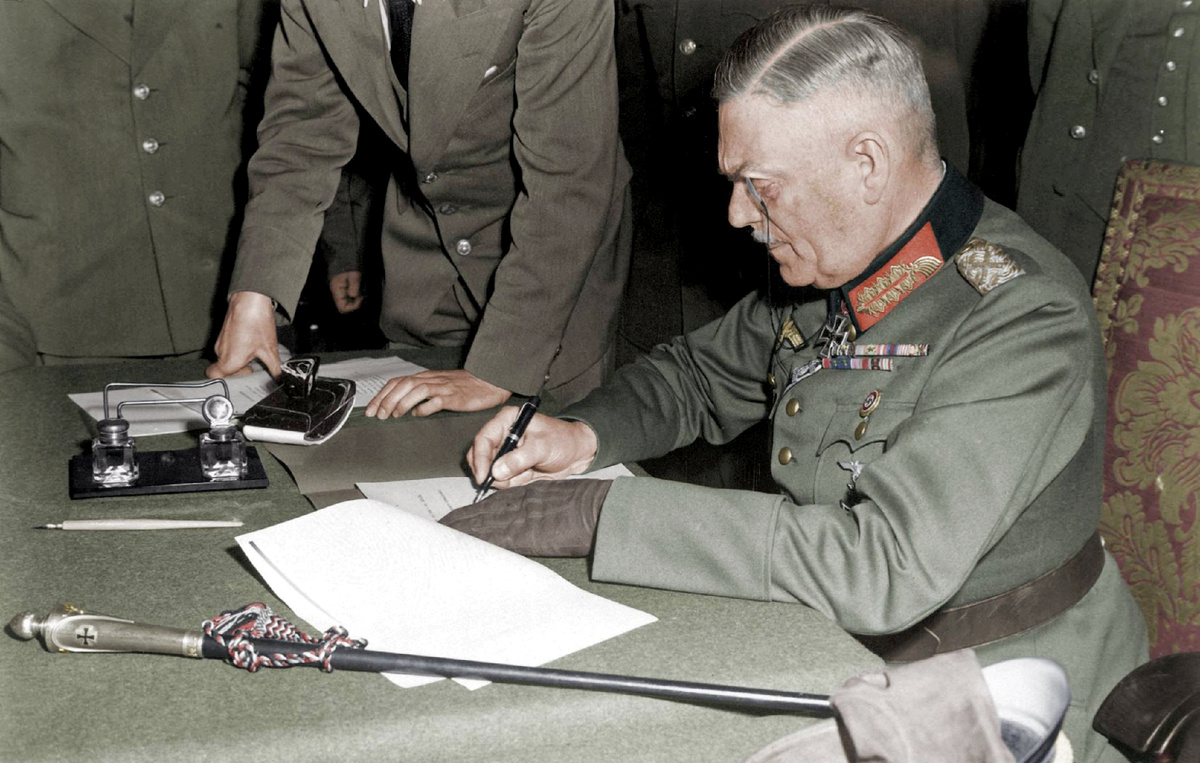 Подписывает акт о безоговорочной капитуляции

