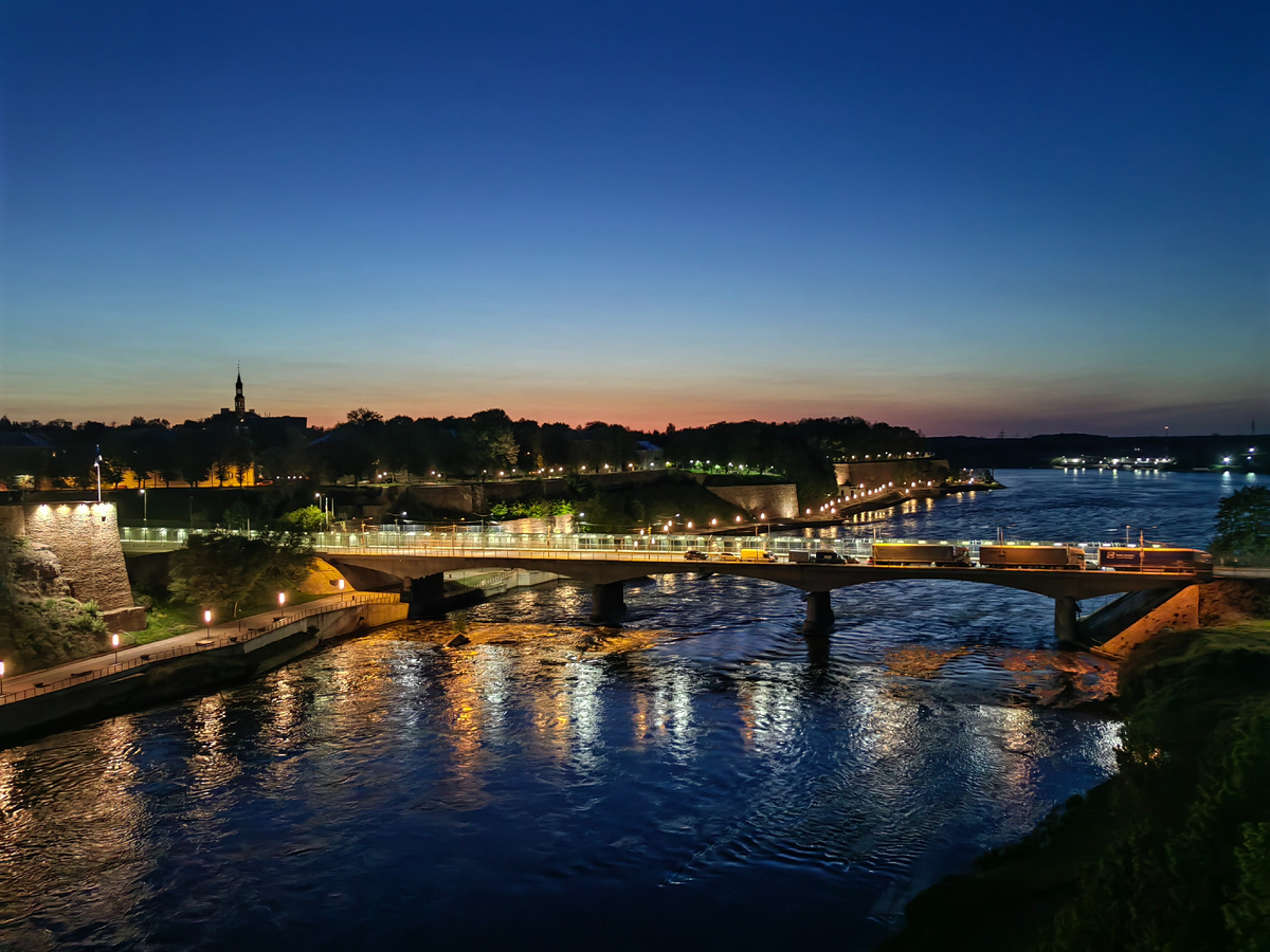 Вид с крепостной стены на реку Нарву, по которой проходит государственная граница, мост Дружбы и город Нарву. 