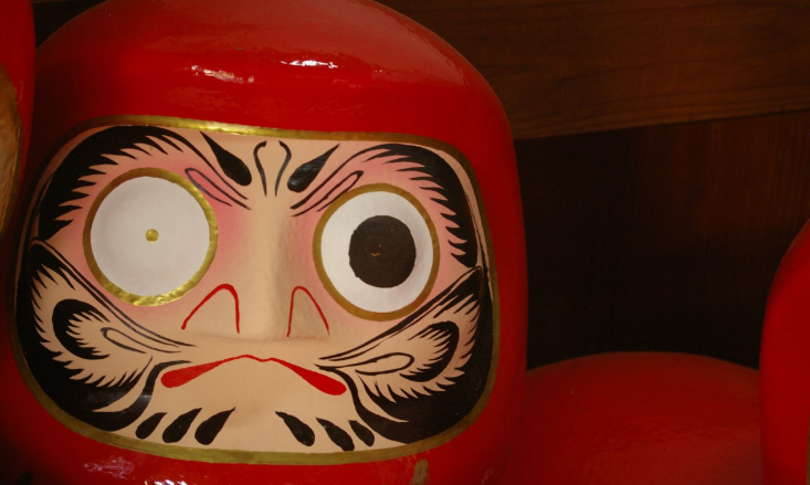 Дарума с загаданным желание сидит и очень старается!