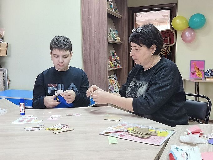 Некрасова Татьяна Николаевна помогает мальчику создавать аппликацию
