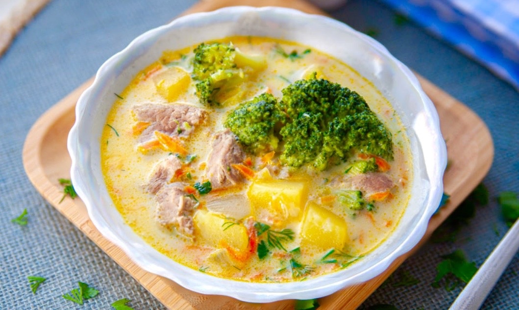 Уха с копченой красной рыбой, овощами и брокколи.