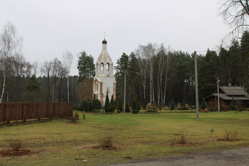 По центру колокольня, справа деревянный храм, построенный по древним меркам и названный в честь святого Димитрия Солунского