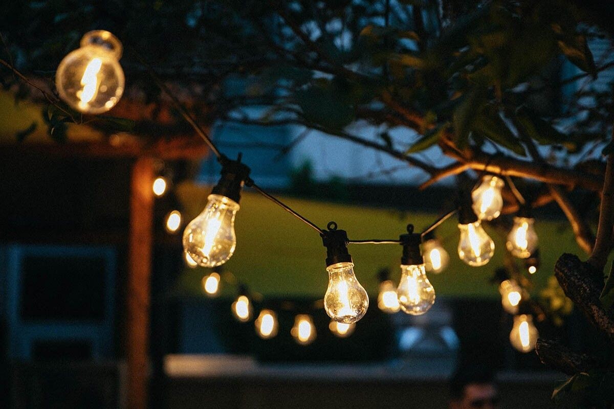 Растяните провод между домом и деревом: фонарики повиснут в воздухе, как будто их несут эльфы. Источник: Dana Anghel  / Shutterstock / FOTODOM📷
