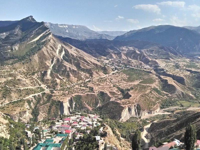 Горные виды Дагестана с панорамой Гуниба и серпантинами, уходящими в долины.