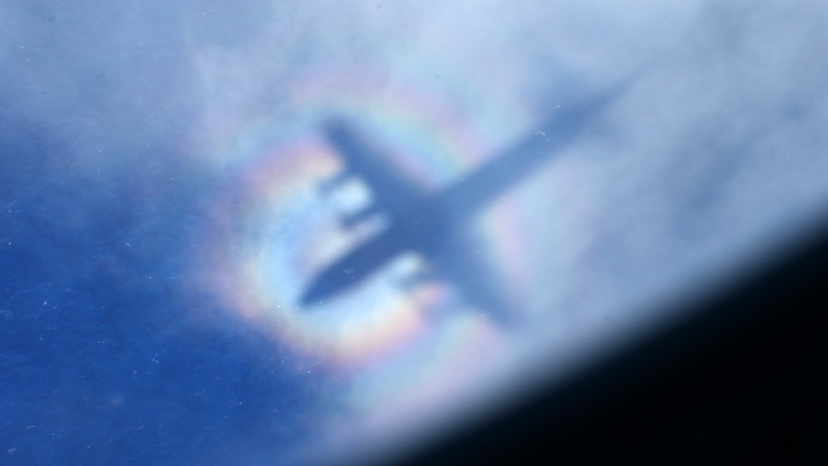   Rob Griffith / AP- Тень от самолета Королевских ВВС Новой Зеландии P3 Orion на фоне низких облаков во время поисков пропавшего рейса MH370 авиакомпании Malaysia Airlines в южной части Индийского океана, 31 марта 2014 года