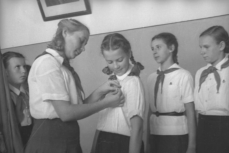 Аллегорическое изображение, созданное для визуализации давления, формализма и страха, которые могли сопровождать пионерскую жизнь. Цель — показать контраст между официальной идеологией и внутренними переживаниями ребенка.