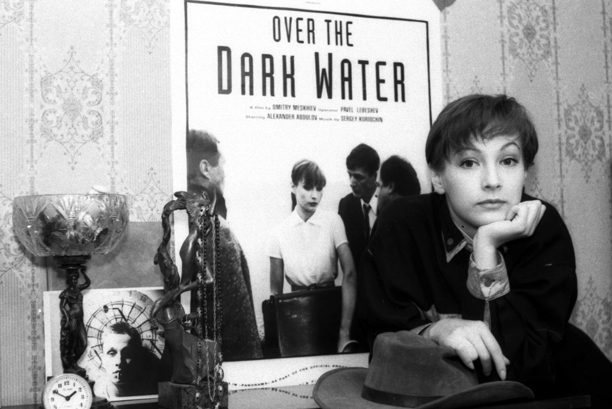 Ксения Качалина на фоне постера к фильму «Над темной водой»