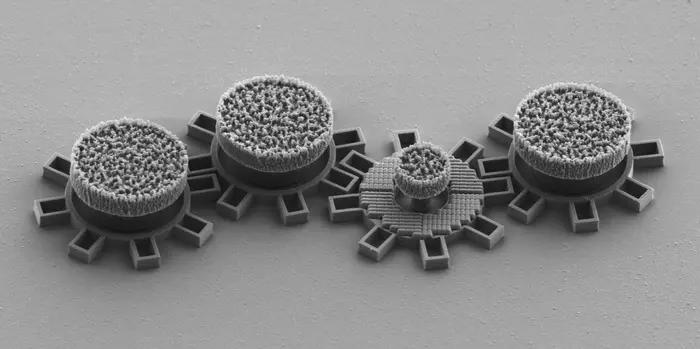 Третья шестерёнка справа изготовлена ​​из оптического метаматериала, который реагирует на лазерный луч и приводит её в движение. Все шестерёнки изготовлены из кремния непосредственно на кристалле. Диаметр каждой шестерёнки составляет около 0,016 мм.