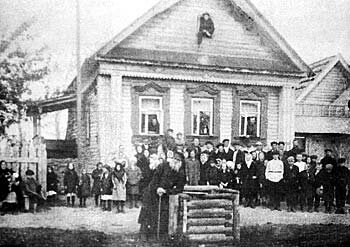 У дома разбойника Чуркина в деревне Барская Богородского уезда Московской губ. Брат разбойника стоит у колодца. Любительское фото Нач. ХХ в.