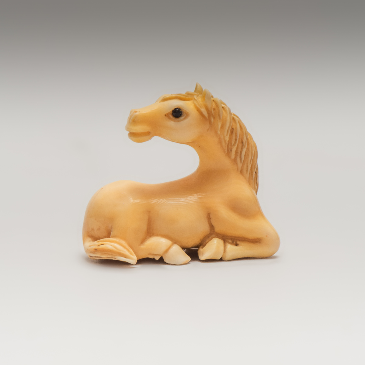 Нэцкэ «Лежащая лошадь»
Япония, XX век
Кость, резьба, тонировка, инкрустация
Высота: 2,5 см