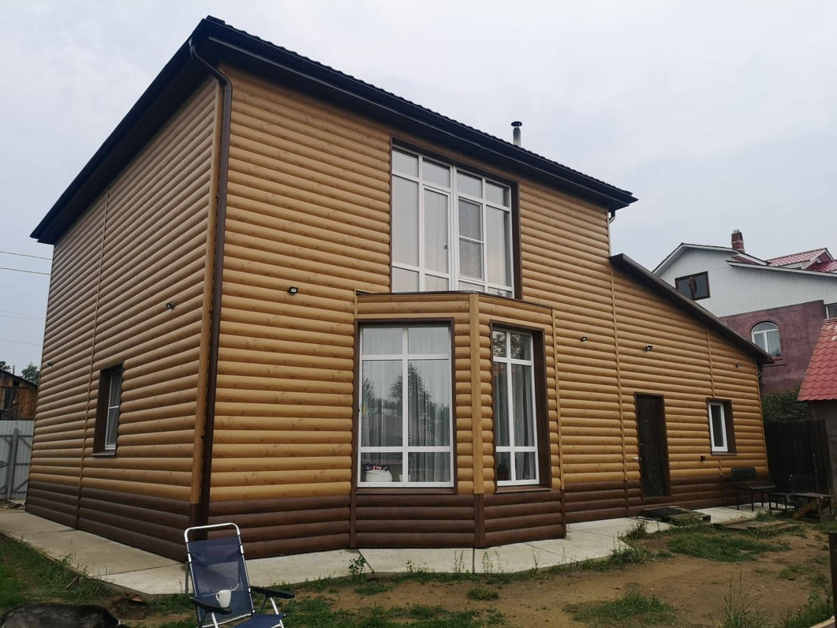 Дом, обшитый металлическим сайдингом под бревно