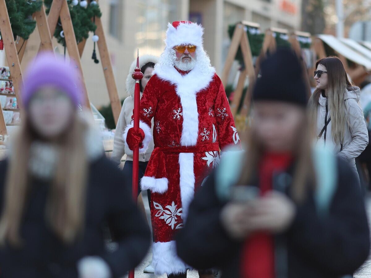    Дед Мороз и отдыхающие на рождественской ярмарке рядом с центральным пляжем в Анапе© РИА Новости / Виталий Тимкив