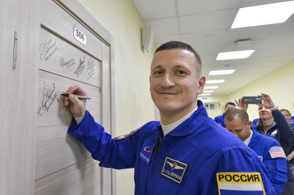Сергей Кудь-Сверчков оставляет автограф на двери номера гостиницы «Космонавт» космодрома Байконур. Фото: Роскосмос