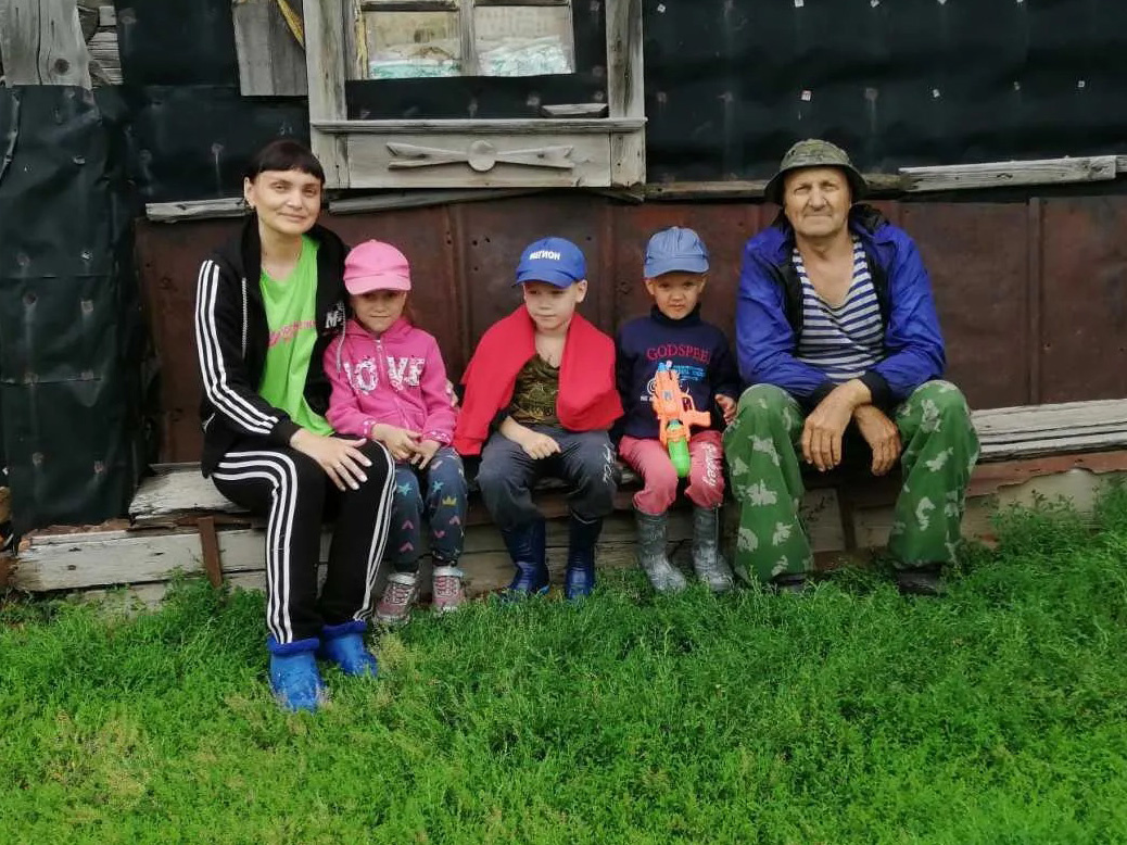 Старожил деревни Тёмной Валерий Курочкин сидит у своего старенького пятистенника.
Племянница Татьяна Мясникова с детьми гостит у дяди, лето 2022 года