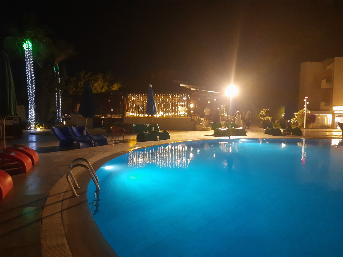 Ресторан за бассейном  светится огоньками 