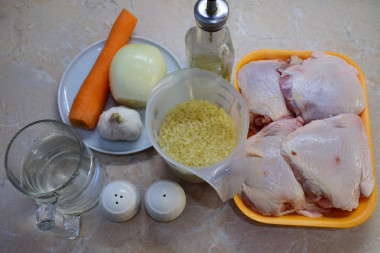 Как сделать плов из курицы на сковороде? Подготовьте для этого все необходимые ингредиенты. Для плова можно использовать любые части курицы. Я буду готовить из куриных бёдер. Рис берите длиннозёрный. Он меньше подвержен развариванию. Лук и морковь очистите от кожуры и ополосните в проточной вод