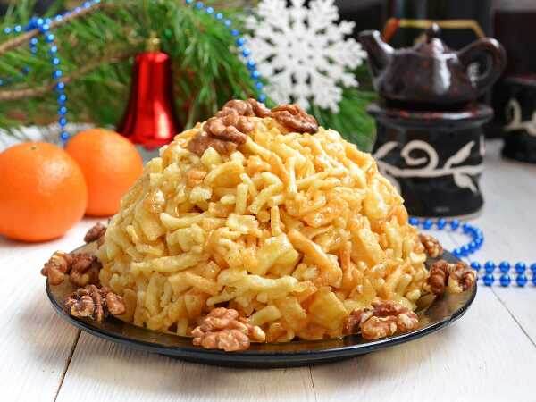 Где пробовать: Казань, Набережные Челны.
Это не просто десерт, это визитная карточка татарской и башкирской кухни и символ гостеприимства. Чак-чак представляет собой брусочки или шарики из теста, обжаренные во фритюре и залитые горячим медовым сиропом.
Почему стоит попробовать: В отличие от магазинного аналога, свежий домашний чак-чак невероятно мягкий, нежный и ароматный. Он буквально тает во рту. Это идеальное лакомство к чаю и отличный сувенир из поездки.