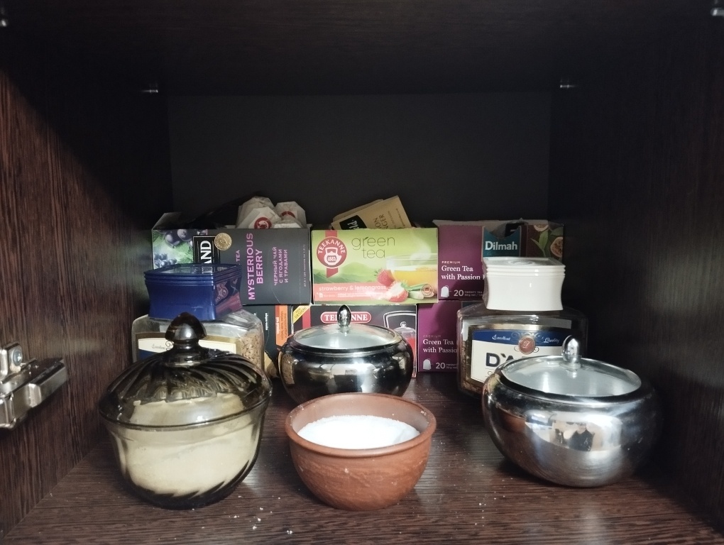 Нижняя полочка шкафа с чаем и кофе.